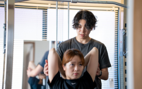 筋トレをする女性とトレーナーの男性